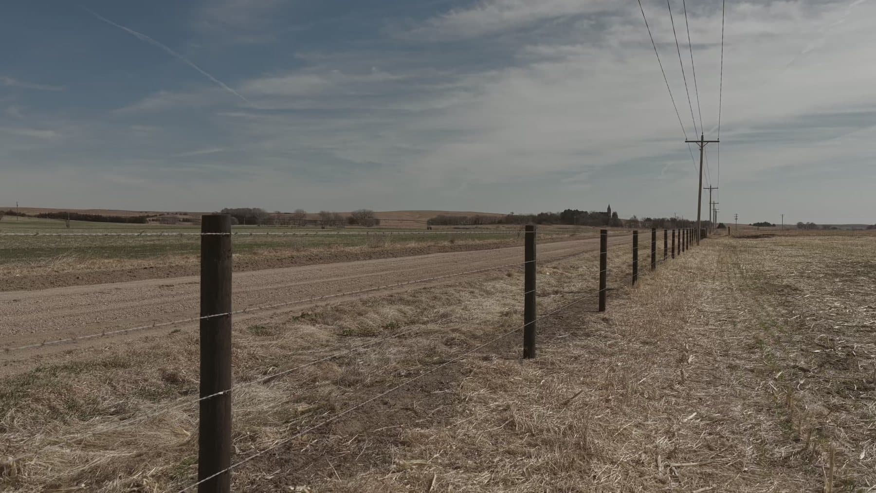 Barbed wire fence line running across open Central Nebraska pasture.